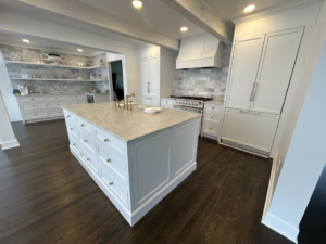 A newly renovated modern white kitchen with a large island and marble countertops, completed by Safe Haven Home Services in Nashville, TN.