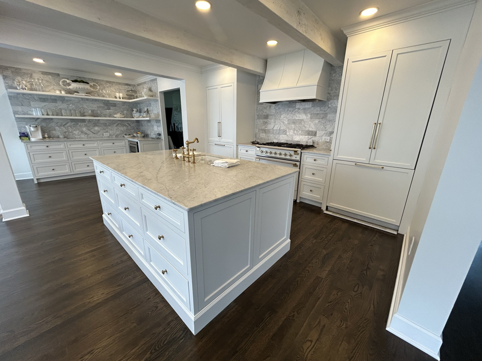 A newly renovated modern white kitchen with a large island and marble countertops, completed by Safe Haven Home Services in Nashville, TN.