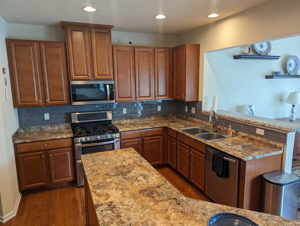 A beautifully renovated kitchen featuring new cabinets, backsplash, and countertops by Mr. Handyman of Northern Pittsburgh, PA.