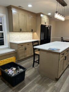 A kitchen renovation in progress, showing new light wood cabinets and white countertops installed by RW Contracting Phila, LLC in Philadelphia, PA.