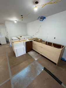 A kitchen renovation in progress with new cabinets and exposed wiring by Alloway Construction & Restoration Inc in Skillman, NJ