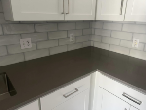 Corner view of a modern kitchen renovation featuring new cabinets, countertop, and backsplash by Fox Solutions Corp in Worcester, MA