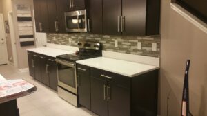 A kitchen renovation featuring dark cabinets, white countertops, and a mosaic tile backsplash by ALKA Construction/ Handyman Services in Layton, UT