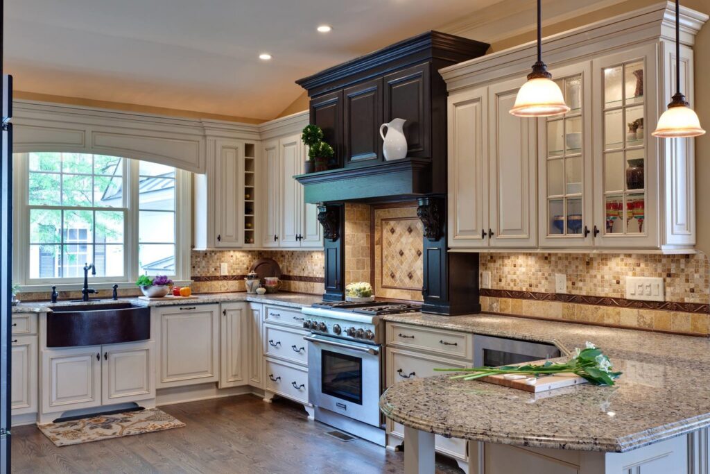 A kitchen renovation showcasing white cabinets, granite countertops, a tiled backsplash, and a farmhouse sink by Surfaces By Design in Duluth, MN.