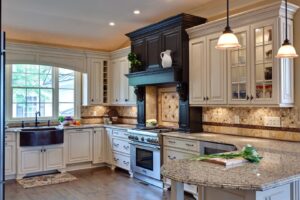 A kitchen renovation showcasing white cabinets, granite countertops, a tiled backsplash, and a farmhouse sink by Surfaces By Design in Duluth, MN.