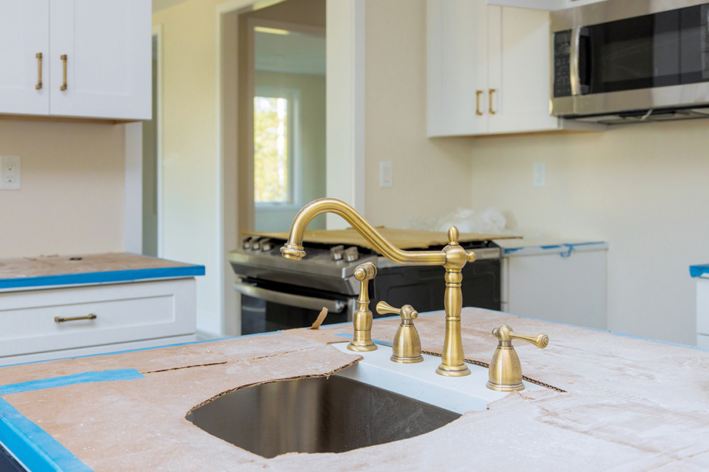 A kitchen undergoing renovation with a new faucet installed and countertops protected by Punchlistit in Lenexa, KS.