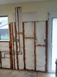 Kitchen renovation showing exposed wall framing, insulation, and plumbing by Cal Heights Construction And Handyman Services in Bakersfield, CA