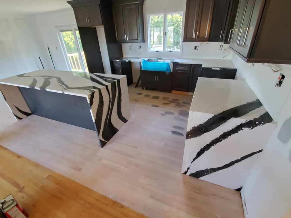 A modern kitchen renovation featuring unique black and white granite countertops by Centennial Granite in New Haven, CT.