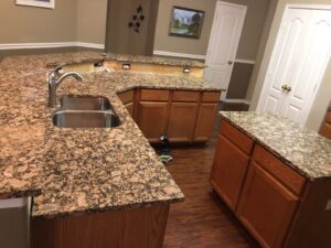 A completed kitchen renovation featuring granite countertops and wooden cabinets by MC Master Construction in League City, TX