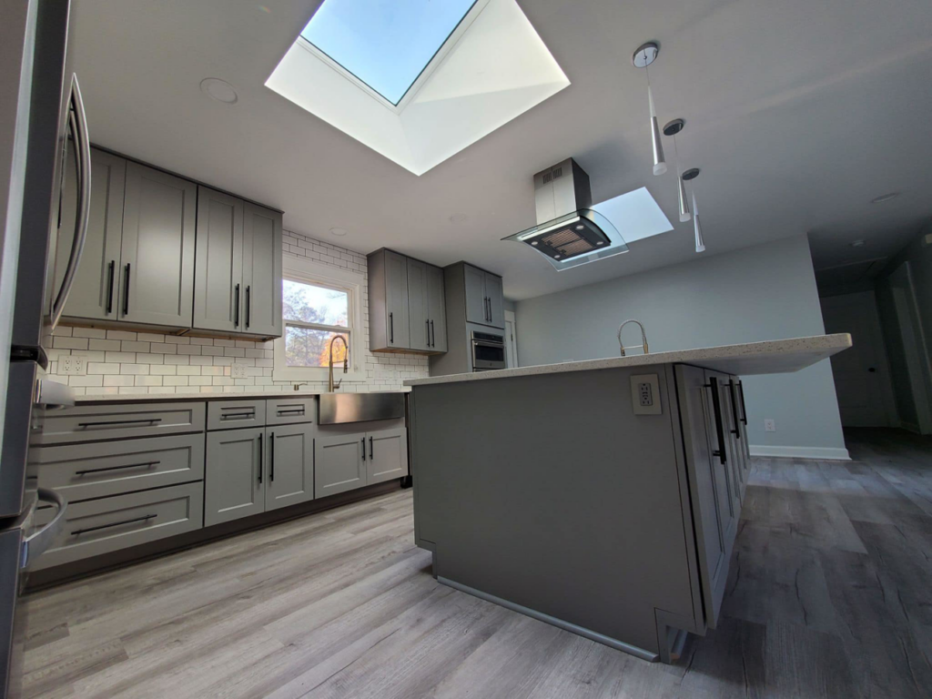 A stylish kitchen renovation with gray cabinets, subway tile, and a skylight by D and R Professional Home Services in Services Available In.