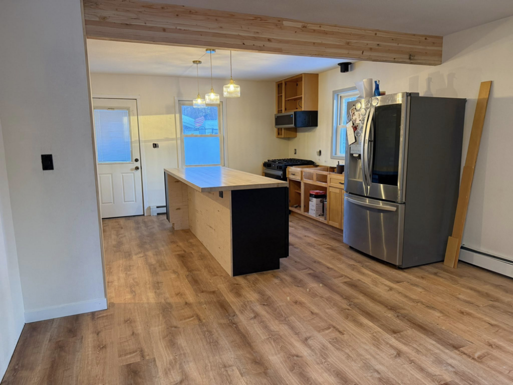 A kitchen undergoing renovation with new flooring and island installed by Ground Up Services in Anchorage, AK.