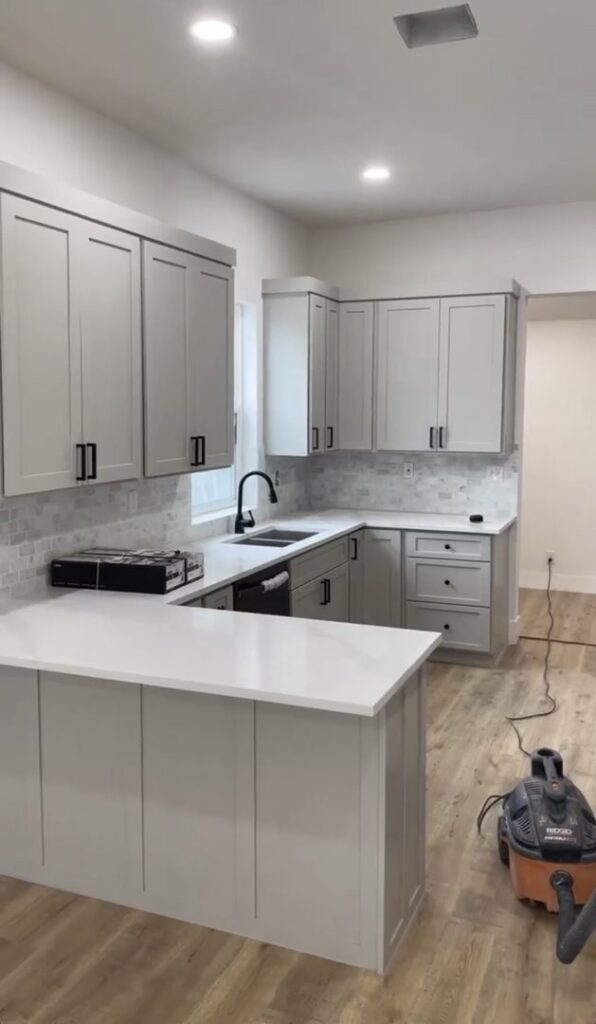A recently completed kitchen renovation with new grey cabinets and countertops by A&R Home Improvements in El Paso, TX