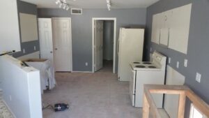 A kitchen undergoing renovation with cabinets removed by Priority One Home Repair LLC in Glendale, AZ