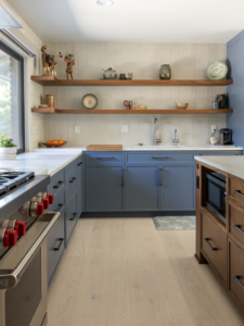 A kitchen renovation showcasing blue cabinets, open shelving, and a new sink by JDI Construction in Vancouver, WA.