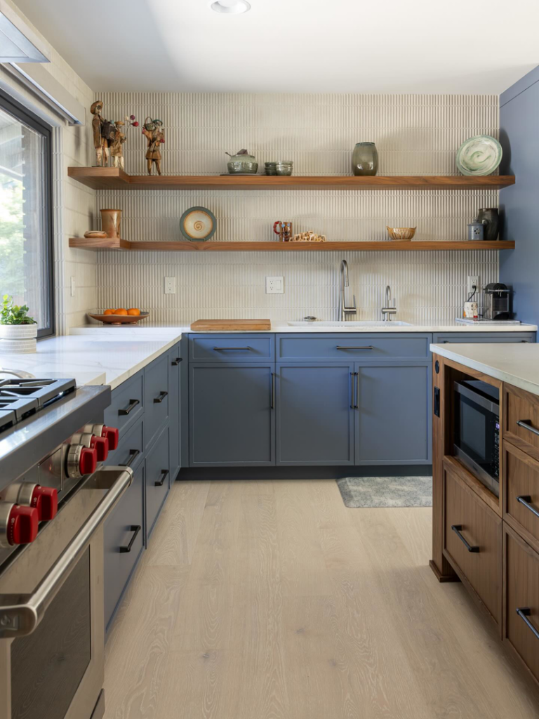 A kitchen renovation showcasing blue cabinets, open shelving, and a new sink by JDI Construction in Vancouver, WA.