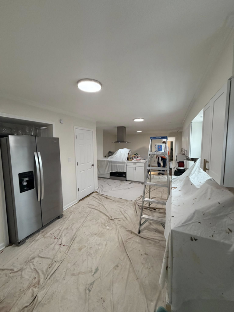 A kitchen prepared for painting or renovation with drop cloths and a ladder by HandyWorx Home Services LLC in Kenna, WV.