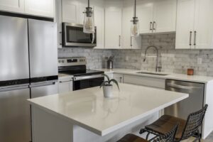 A contemporary kitchen renovation featuring white cabinets and a subway tile backsplash by Gordon T. Jacob in Tacoma, WA