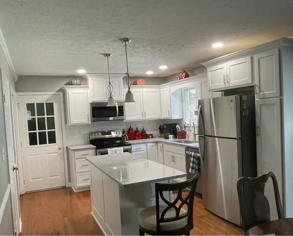 Completed kitchen renovation with white cabinets, a light island, and stainless steel appliances by Blue Ribbon Renovations in Elizabethtown, KY.