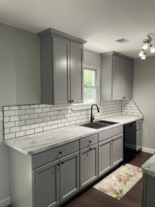 Renovated kitchen sink area with new faucet, marble-look countertops, and subway tile backsplash by Wareham Home Improvements in Frederick, MD.