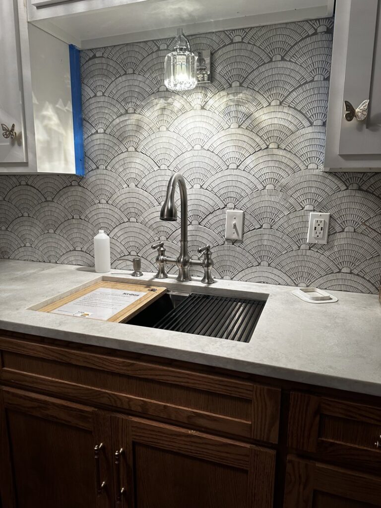 Newly installed kitchen sink, faucet, and decorative backsplash by Ricos Renovations in Arlington, TX