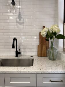 A close-up of a kitchen sink area with a white subway tile backsplash, expertly installed by Westrick Homes in St. Louis, MO.