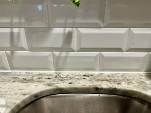 After image showing fresh, clean caulk around a kitchen sink, completed by PODavis Home Helpers in Little Rock, AR