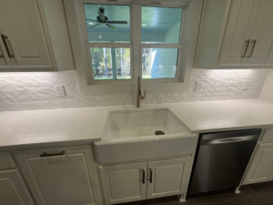 Kitchen featuring a new farmhouse sink, faucet, and dishwasher installed by Adamson Construction Group in Salem, AL.