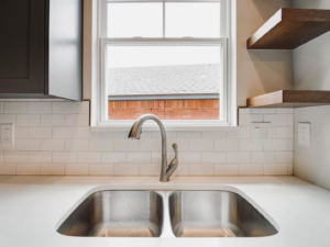 A newly installed kitchen sink with a modern faucet and subway tile backsplash by Power Roofing & Construction in Norman, OK.