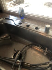 A kitchen sink with an old faucet removed, prepared for a new faucet installation by Mancusi Home Maintenance in Boulder City, NV.