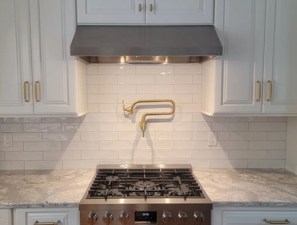 Kitchen stove, pot filler faucet, and range hood installation by Walker Kitchen Design in Granby, CT.