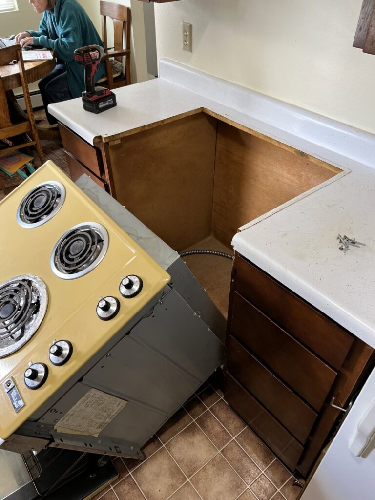 Kitchen area with an old stove removed, showing space for new appliance installation by 1775 Handyman Services in Kalispell, MT.