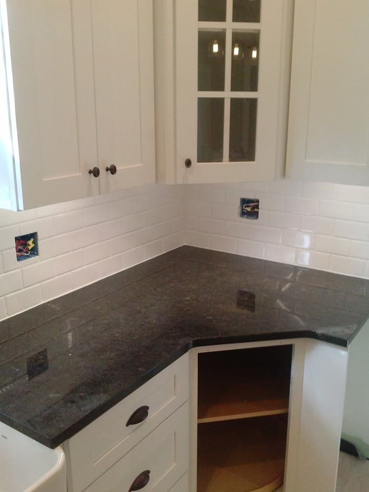 A kitchen featuring newly installed subway tile backsplash and dark countertops, a renovation by K&K Construction LLC in Enid, OK