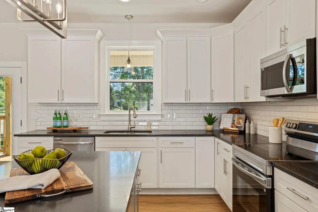 A kitchen with white cabinets and subway tile backsplash installed by Heroic Builders LLC in Greenville, SC.