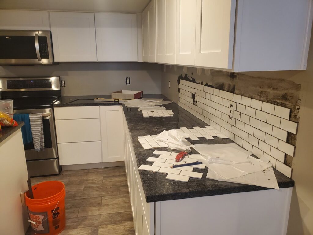 Subway tile backsplash installation in progress in a kitchen by Jonny Handyman Services in Roy, UT.