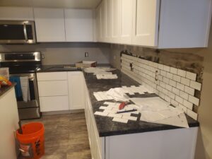 Subway tile backsplash installation in progress in a kitchen by Jonny Handyman Services in Roy, UT.