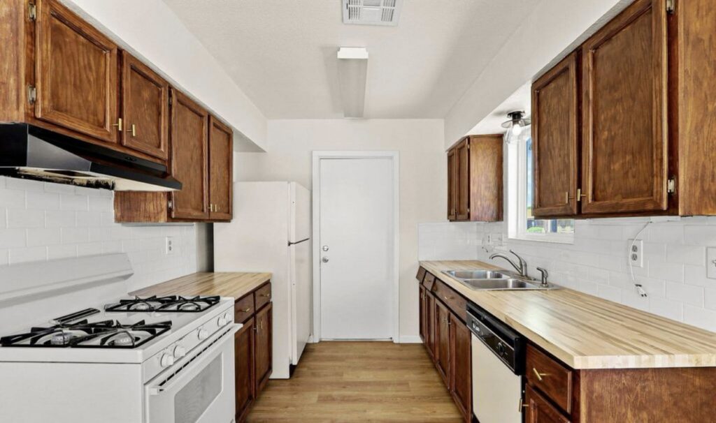 A renovated kitchen featuring wooden cabinets, a white subway tile backsplash, and wood-look countertops by Lay's Remodeling LLC in El Paso, TX