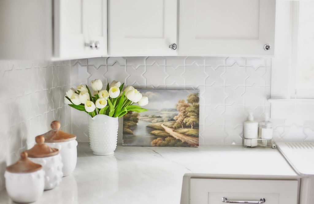 A detailed view of a kitchen with a decorative tile backsplash and clean countertop by ADAMS Pro Finish in Spring Hill, TN.