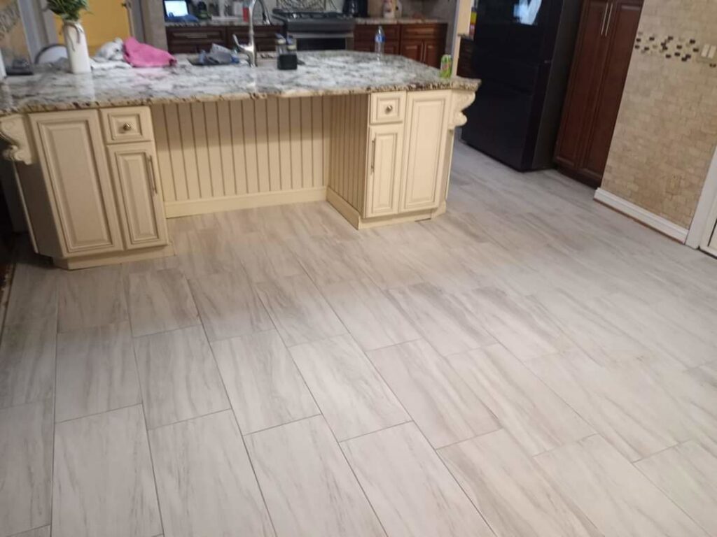 Newly installed light-colored tile flooring in a kitchen by Prime Construction And Flooring in Lorain, OH.
