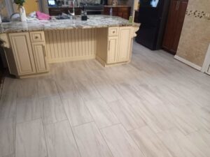 Newly installed light-colored tile flooring in a kitchen by Prime Construction And Flooring in Lorain, OH.