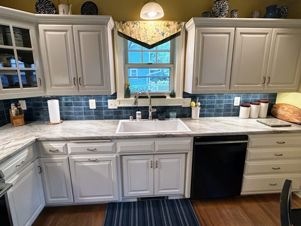 A kitchen update showcasing light gray cabinets, new countertops, and a stylish blue subway tile backsplash by Boisen Remodeling LLC in Appleton, WI.