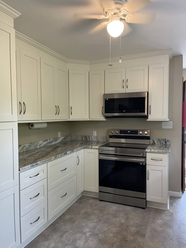 Kitchen upgrade with new white cabinets, countertops, and stove installed by J and R Granite Industry in Columbus, OH.
