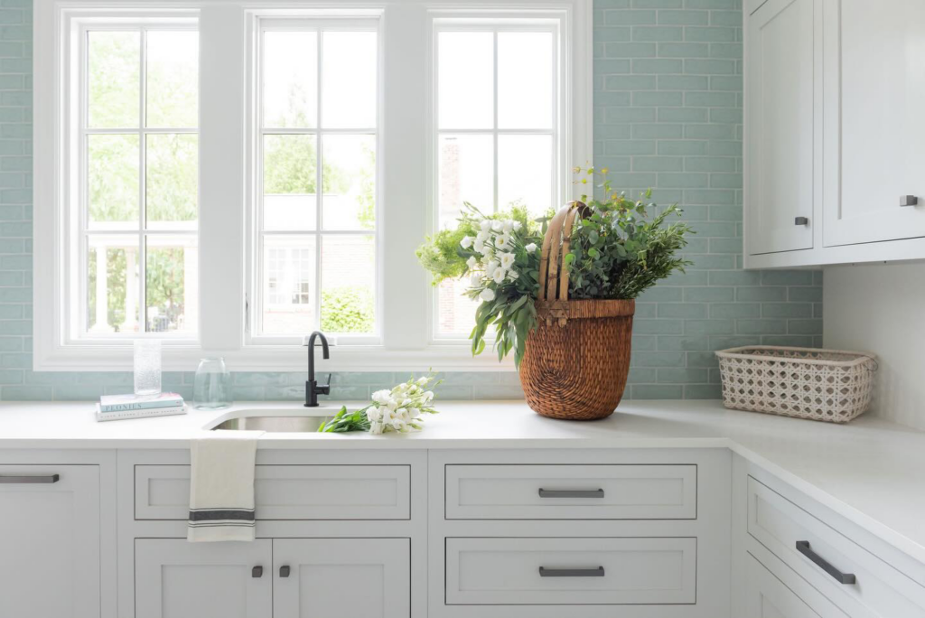 A newly renovated kitchen or utility room with subway tiles, white cabinets, and a dark faucet by Inspiration Homes in Spring Hill, TN