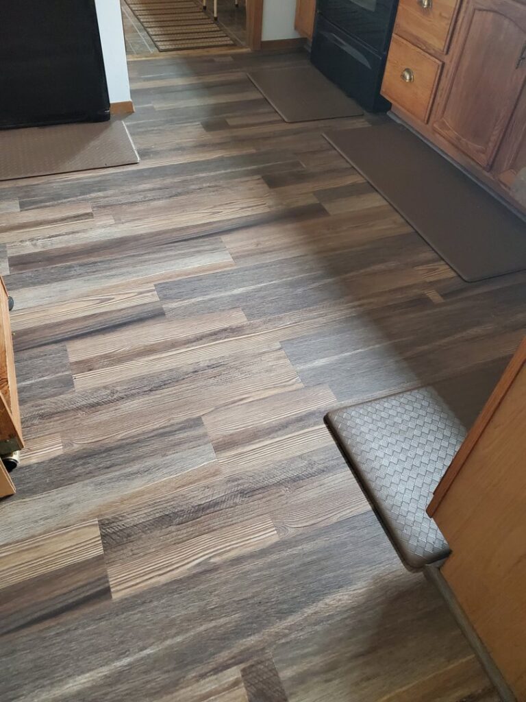 Newly installed wood-look vinyl plank flooring in a kitchen by Creative Carpets in North Las Vegas, NV.