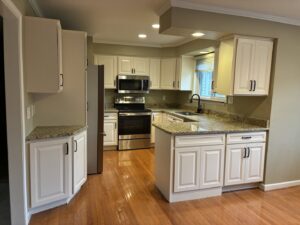 A renovated kitchen with white cabinets, granite countertops, and stainless steel appliances by Creative Building & Remodeling in Warren, MI