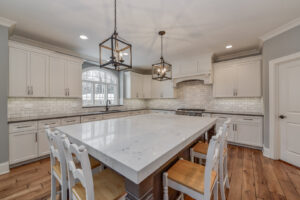 A spacious kitchen featuring white cabinets, a large island, and subway tile backsplash, built by Autumn Homes in Naperville, IL.