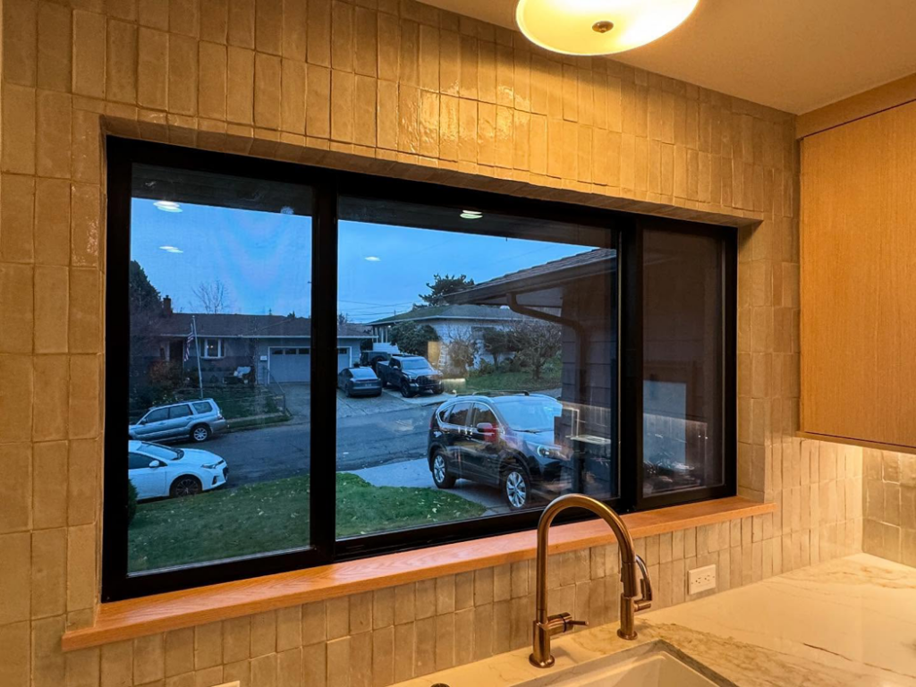 Kitchen window with new tile backsplash and faucet installation by Balance Painting & Remodeling, LLC in Portland, OR.