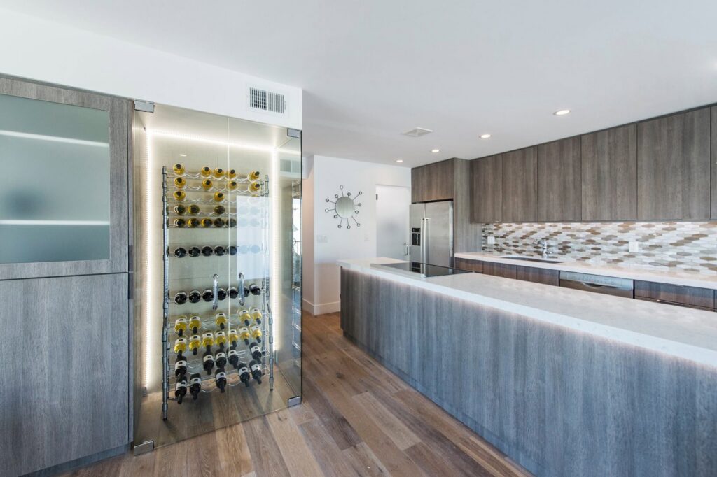 A modern kitchen featuring a built-in wine rack and under-cabinet lighting installed by Patterson Homes LLC in Scottsdale, AZ.