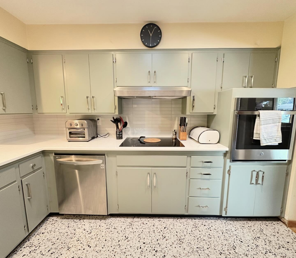 Kitchen with light green cabinets, new white countertops, and subway tile backsplash by Cabinet Refinishing Northwest in Beaverton, OR.