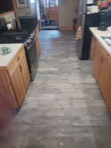 A kitchen featuring newly installed wood-look tile flooring by RS handyman llc in Kenai, AK.