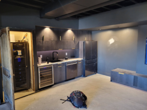A newly installed kitchenette or wet bar with dark cabinets and appliances by Joe Norton's Handyman Service in Williston, ND.